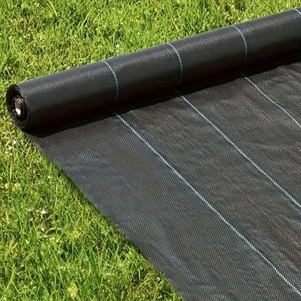 Roll of black woven garden fabric unrolled on a lawn