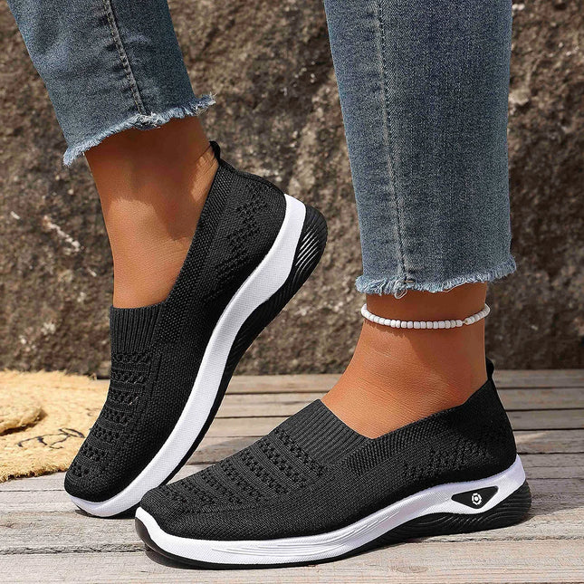 Woman wearing black knit slip-on sneakers