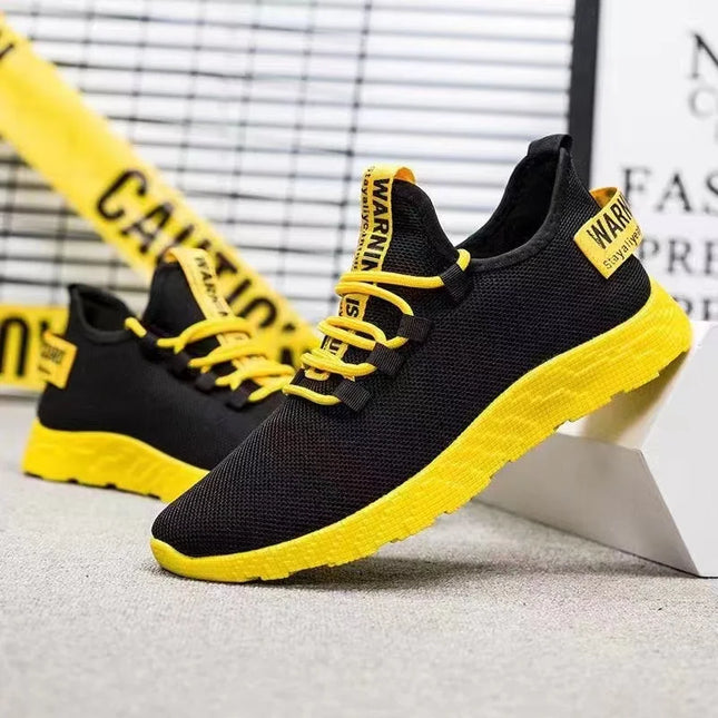 Pair of black mesh sneakers with yellow sole and laces
