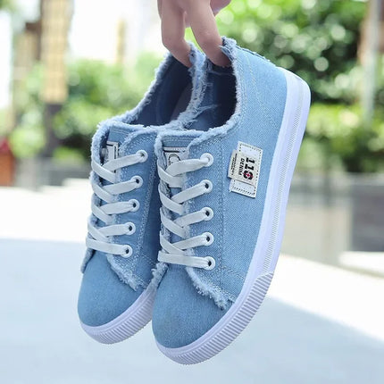 Blue closed-back canvas sneakers held outdoors