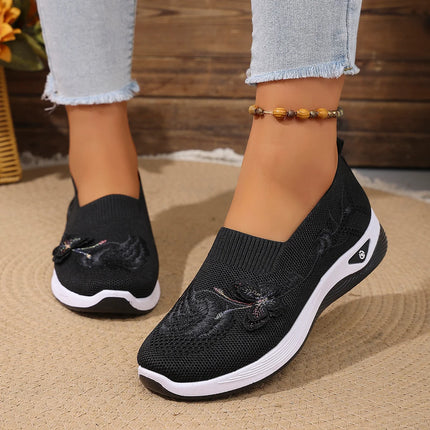 Black floral knit slip-on sneakers worn with light jeans
