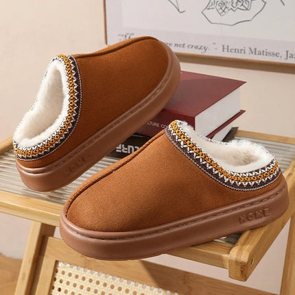 Brown plush-lined house slippers displayed on books