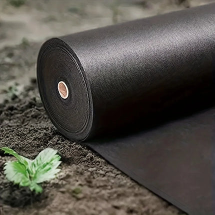 Roll of black non-woven landscape fabric laid out on soil