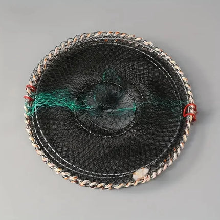 Folded flat circular black fish trap cage on a grey background