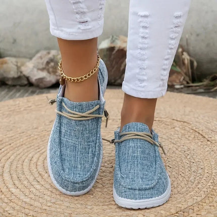 Blue canvas lace-up loafers with moccasin-style seams, worn with white pants