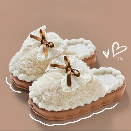 Cream plush house slippers with brown ribbon bows