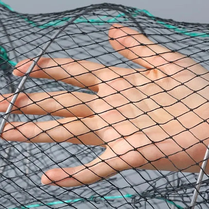 Close-up of a hand beneath black nylon mesh netting