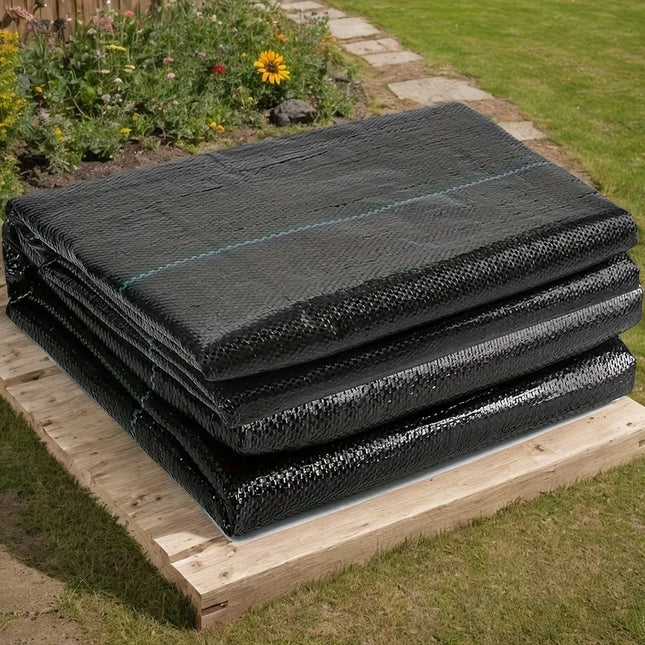 Folded black woven weed barrier fabric on a wooden pallet