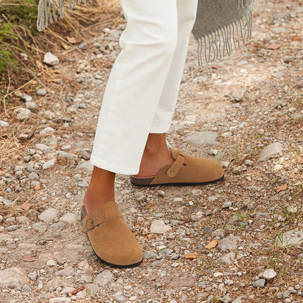 Tan buckle clogs worn outdoors with white pants