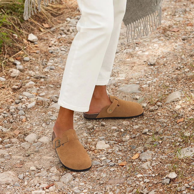 Tan buckle clogs worn outdoors with white pants