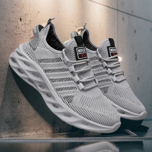 Pair of light gray mesh running sneakers with wavy sole