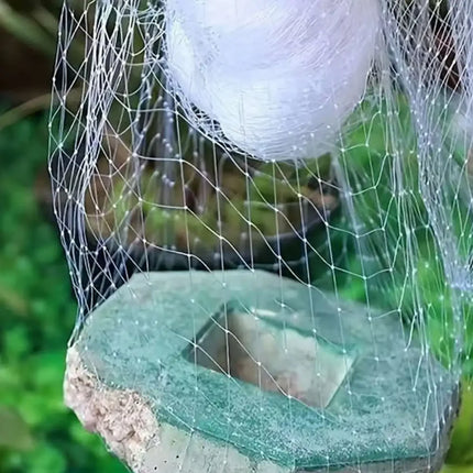 Fine white mesh net stretched over a garden stone fixture