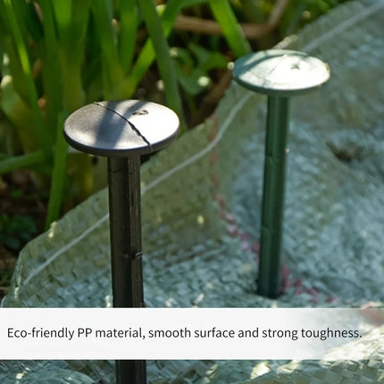 Plastic stakes securing landscape fabric