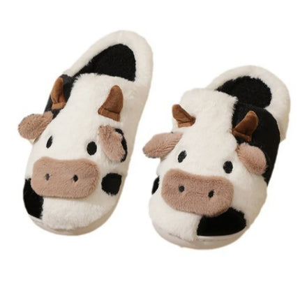 Pair of black-and-white cow house slippers on a white background