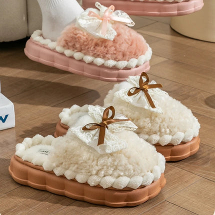 Cream and pink plush bow slippers displayed together