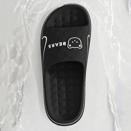 Top view of a black bear-print EVA slide beside water