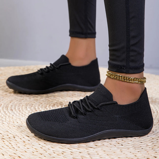 Woman wearing black wide-fit barefoot sneakers