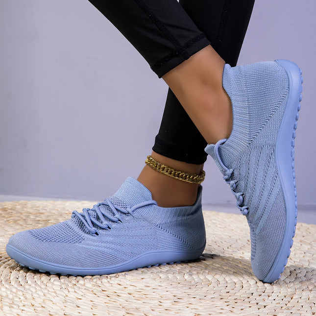 Woman wearing light blue barefoot knit sneakers